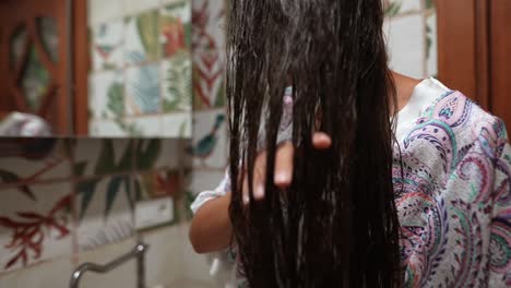 mujer lavando su cabello largo en el baño