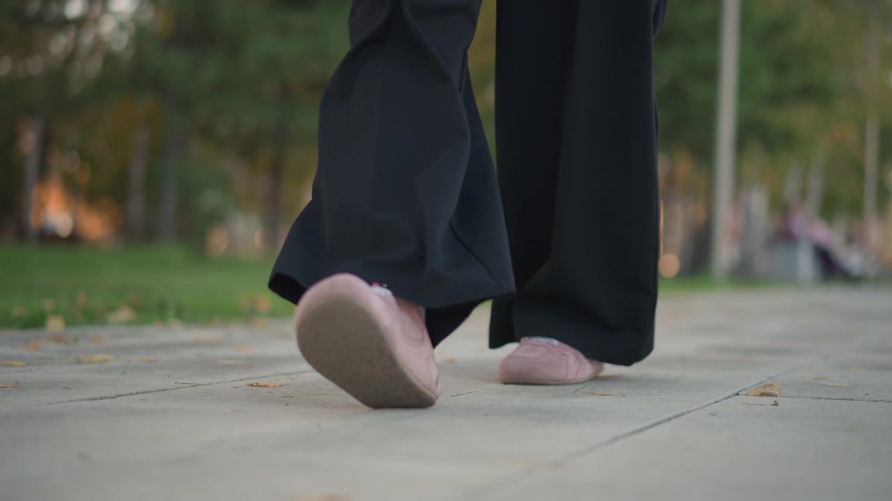 Person Walking in Wide Leg Trousers and Pink Sneakers