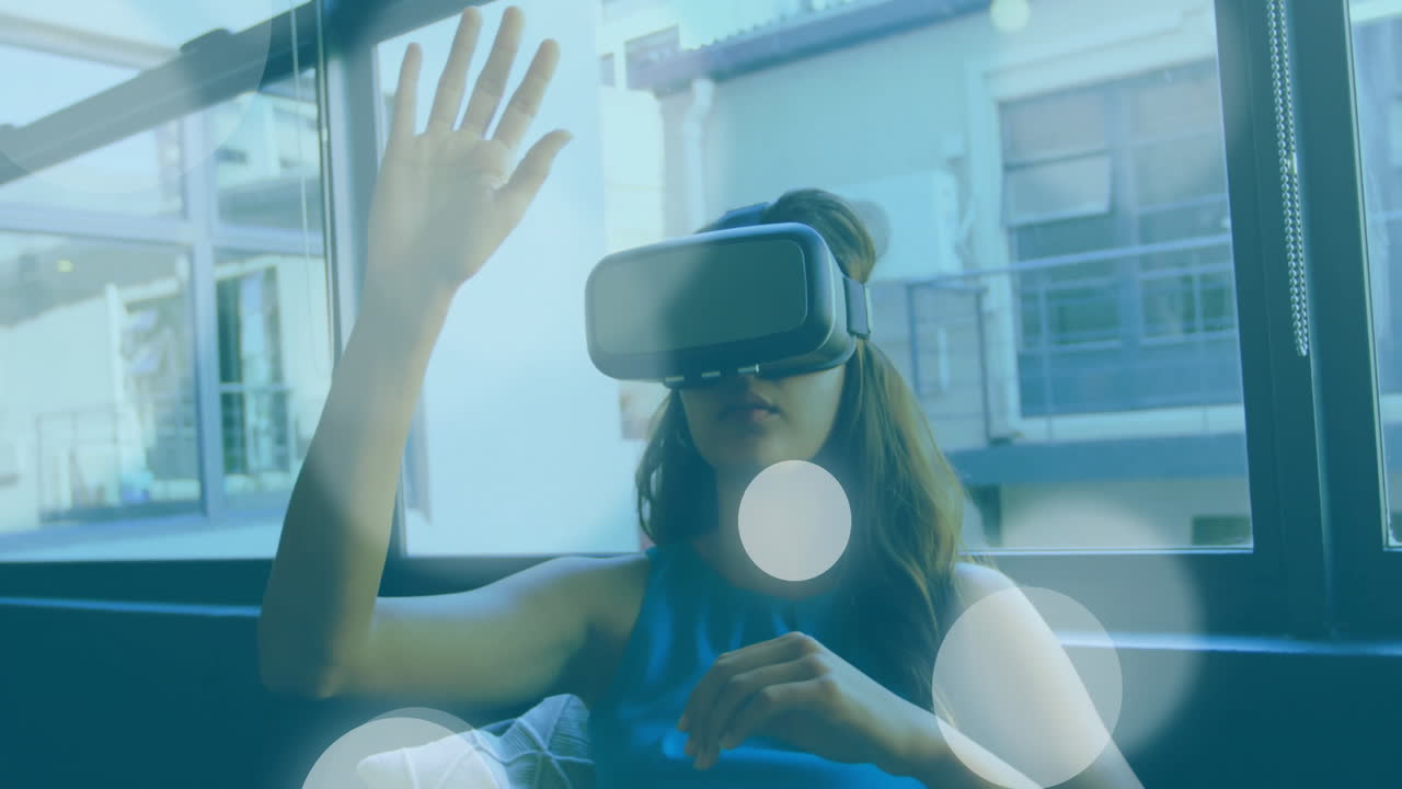 Woman using VR headset in modern lounge, interacting with floating data charts for technology demo