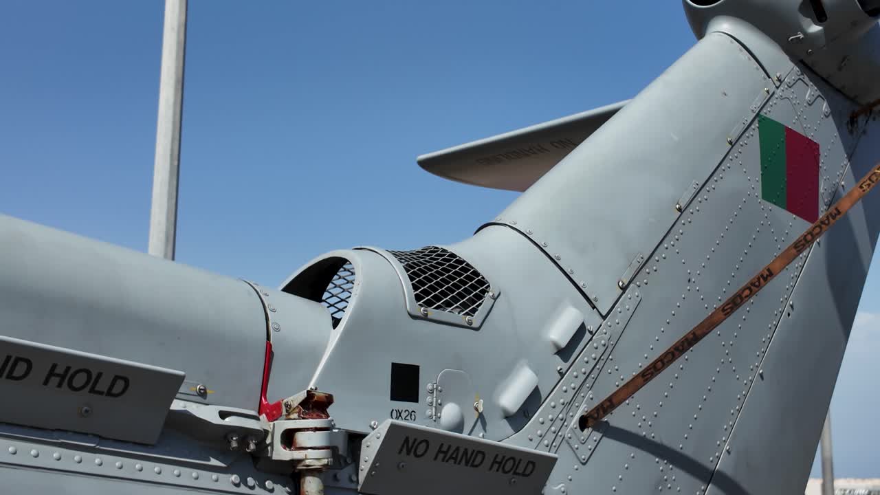 Detailed view of a military helicopter's tail rotor assembly, emphasizing safety warnings and potential hazards