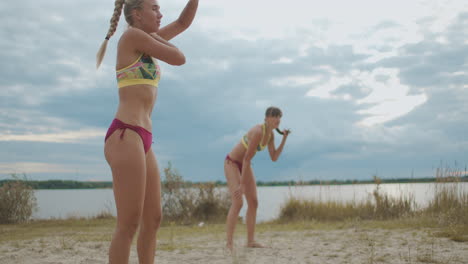 Beachvolleyballspielerinnen-Stehen-Auf-Dem-Sandplatz-Und-Warten-Auf-Das-Aufschlagtraining-Oder-Ein-Inoffizielles-Spiel