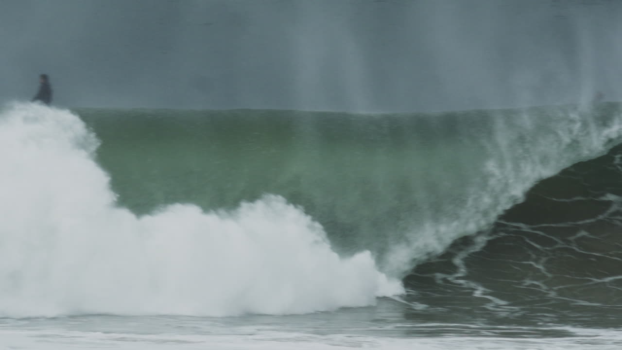 Perfect turquoise wave pitching with hollow shape, sunlit and smooth in calm conditions, telephoto tracking slow motion