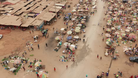 Tilt-up-over-the-informal-market,-Caxito-in-Angola,-Africa-1