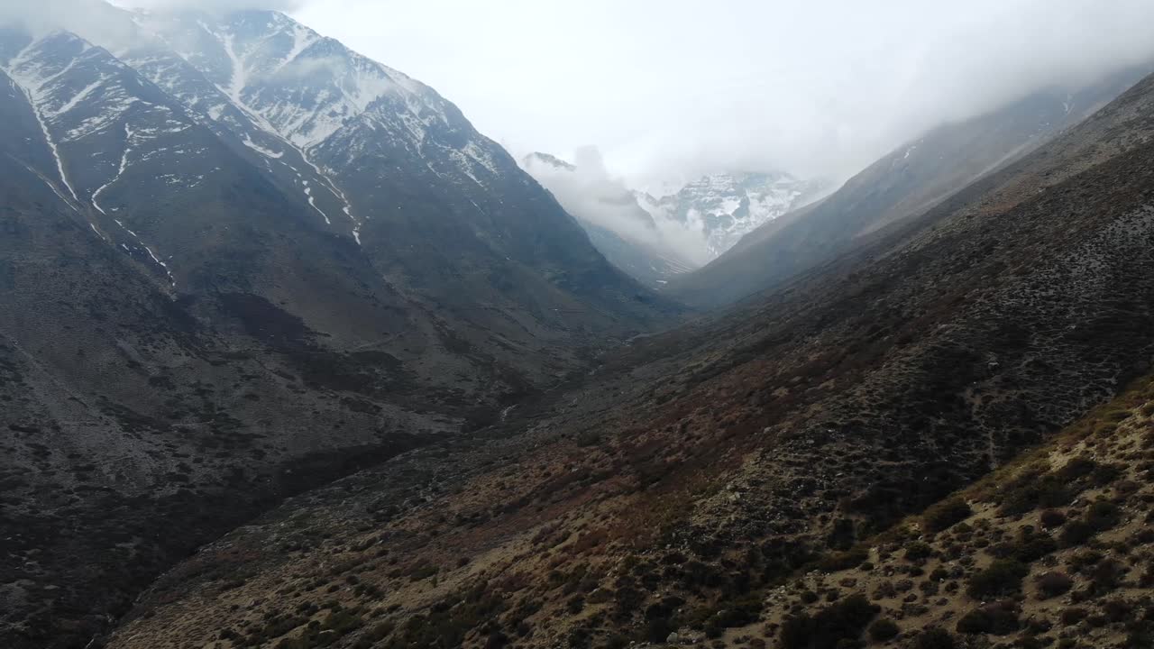 Sorvolando le Ande appena sopra il suolo, avvicinandosi a montagne innevate - 4K.