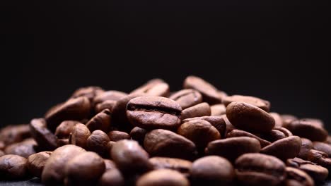 a heap of high-quality roasted coffee beans isolated against black background