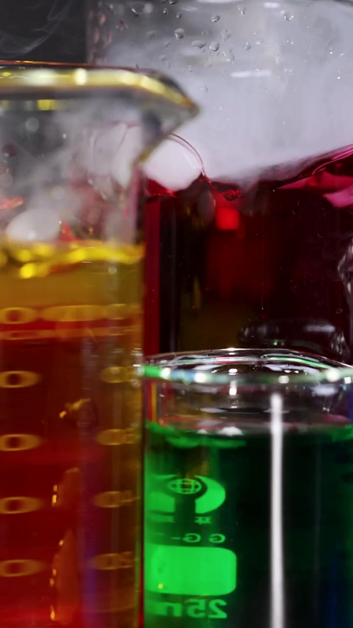 Becher con liquidi colorati e fumo in evaporazione