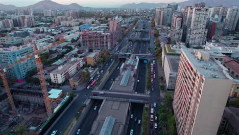 Aerial-view-orbiting-Santiago,-Chile-capital-cityscape-under-Andes-mountain-range-skyline