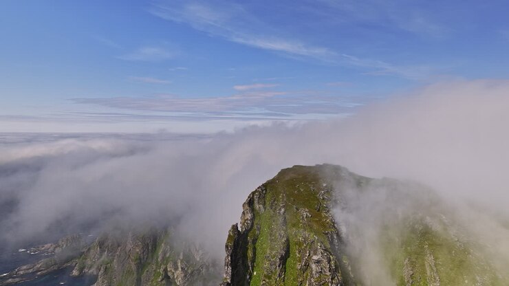 Stave Norway Aerial v19 high altitude drone fly around måtind viewpoint capturing dramatic rocky mountain peak and coastal mountainscape with thick layer of fogs - Shot with Mavic 3 Cine - June 2022