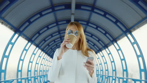 todos los negocios sobre la marcha mujer de negocios con una taza de café y el teléfono se enciende rápidamente en el túnel