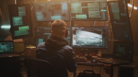 man working in a high-tech control room with multiple monitors
