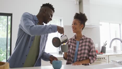 Video-of-happy-african-american-couple-preparing-coffee-at-home