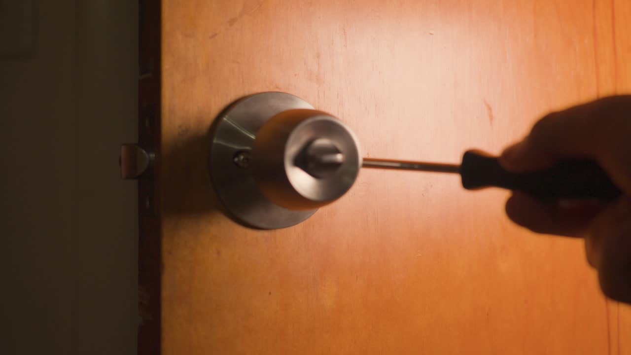 Fissaggio manuale delle viti della maniglia nella sezione interna del pomello della porta.