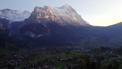 imágenes aéreas de drones empujando sobre el pueblo de grindelwald, impresionantes vistas de la cara norte del eiger al atardecer
