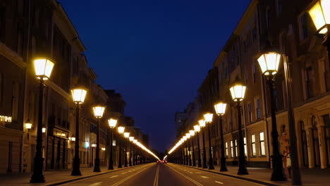 night street lined with illuminated lamps