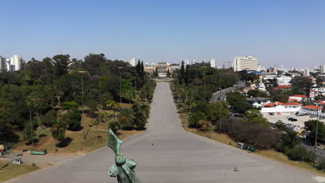 toma aérea que se eleva hacia abajo y revela el monumento a la independencia en el parque de la independencia con el museo ipiranga al fondo de la escena