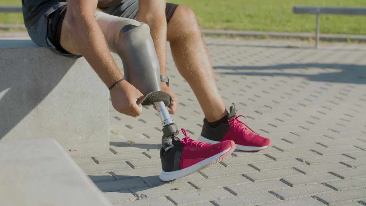 Closeup of male athlete removing his prosthetic leg.