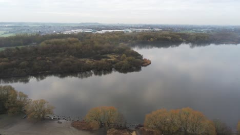 Foggy-dawn-misty-colourful-nature-reserve-autumn-woodland-lake-landscape-aerial-dolly-left