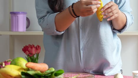 woman peeling banana for preparing making healthy smoothie homemade