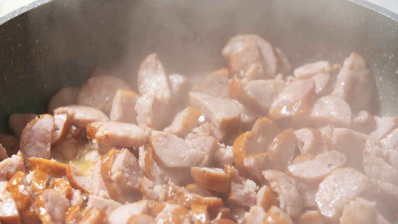 Frying Sausages On Pan In Kitchen