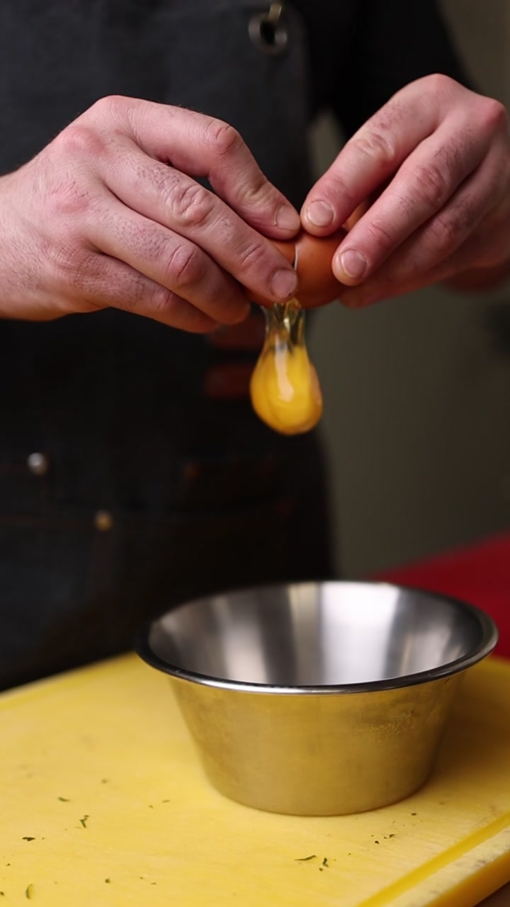 Close-up of Hands Cracking and Separating an Egg into a Bowl