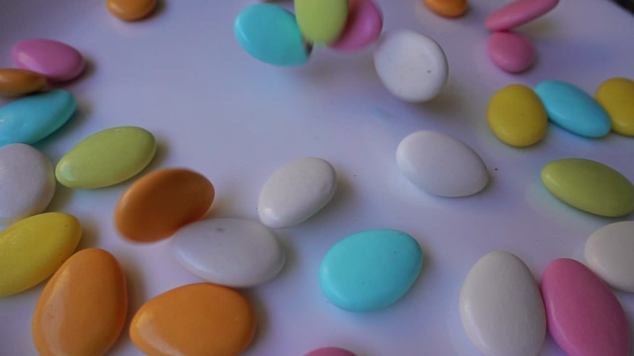 Pile of chocolate-covered almonds or colored pine nut almonds. Easter season