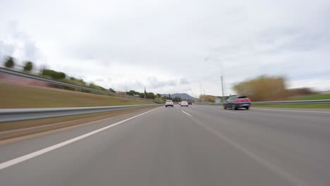 Conduciendo-Un-Automóvil-En-La-Autopista-De-Barcelona-En-España,-Cámara-Rápida-Montada-En-El-Lapso-De-Tiempo-Frontal-Con-Desenfoque-De-Movimiento-Día-Nublado