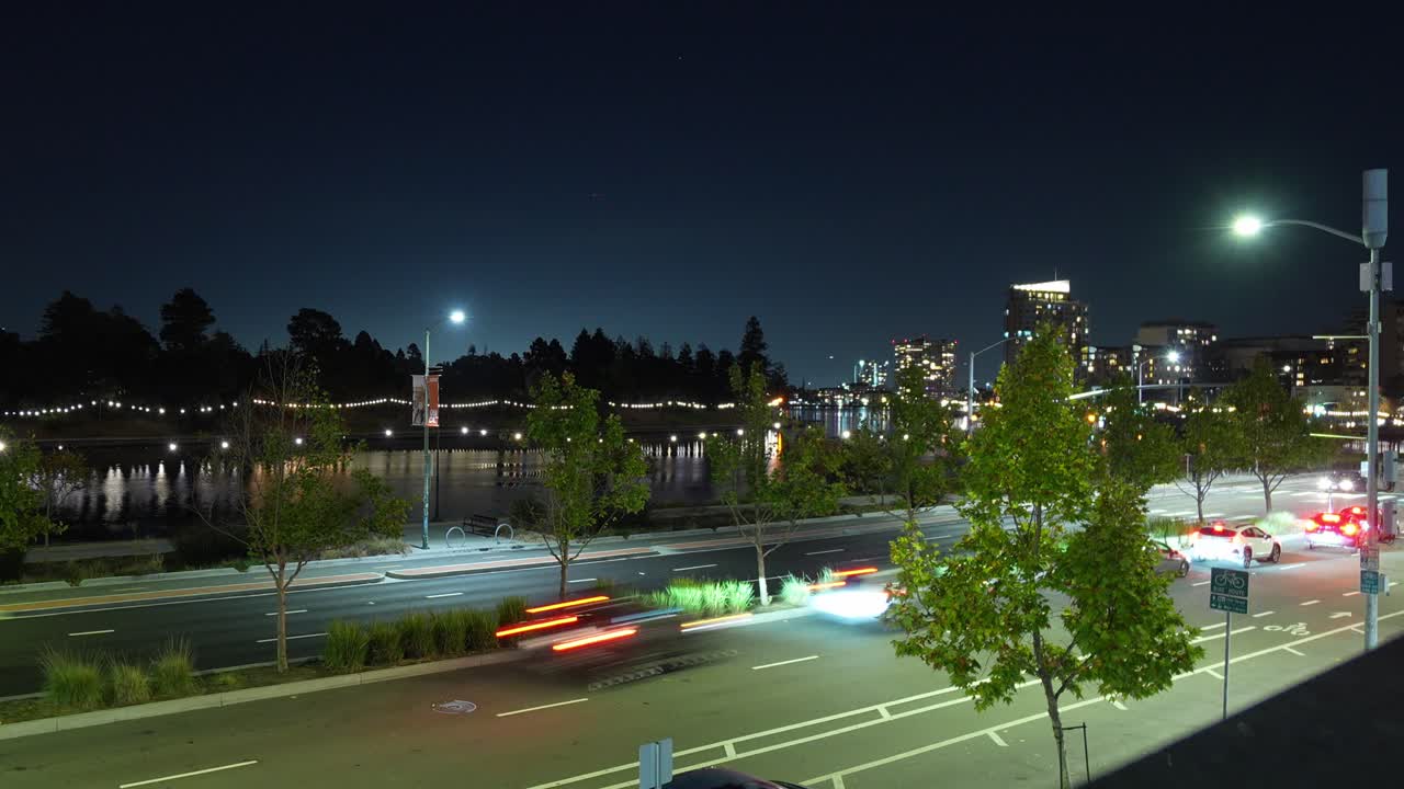 Evening time lapse views from Harrison Street show Lake Merritt’s surface shimmering while the city skyline gradually illuminates, blending motion and calm across downtown Oakland