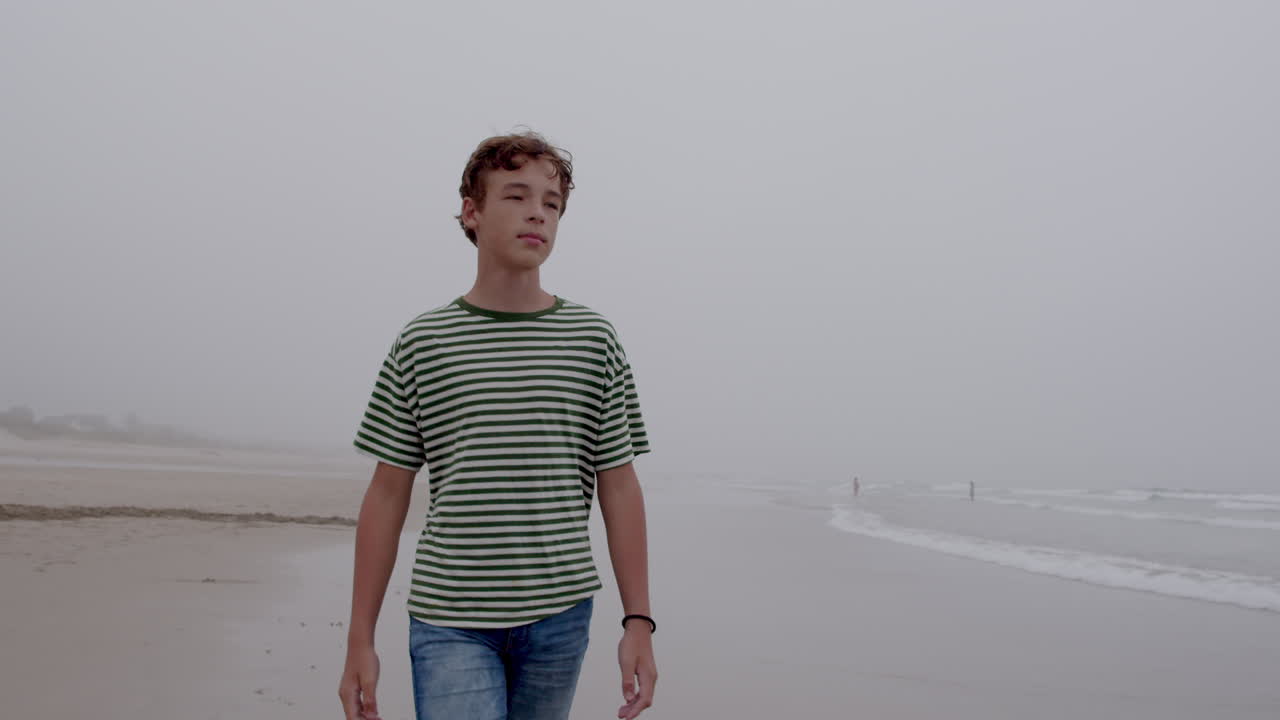 Teenager Walking on a Foggy Beach