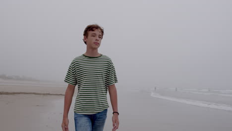 teenager walking on a foggy beach