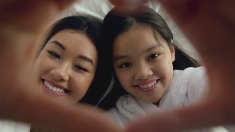 mother and daughter heart selfie