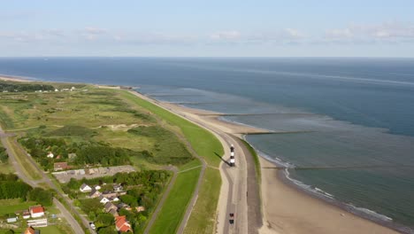 aerial orbit over the lighthouse on the shore of waterdunes - a nature area and recreational park in the province of zeeland, the netherlands