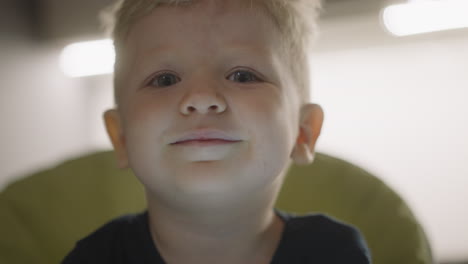 adorable toddler boy smiles looking in camera at home