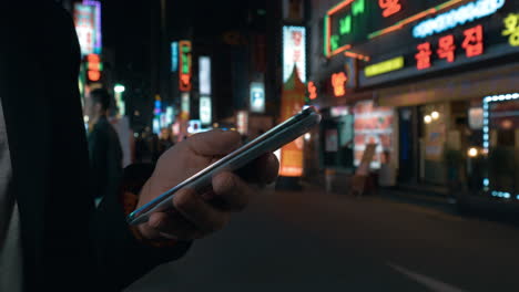 Mujer-Navegando-En-Línea-En-El-Celular-En-La-Noche-De-Seúl,-Corea-Del-Sur