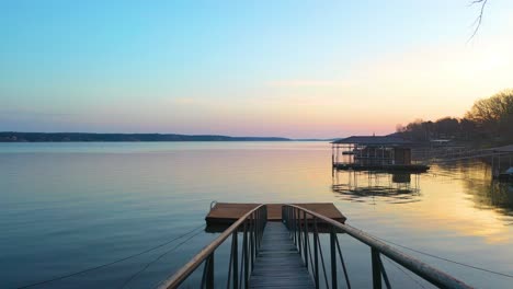 wooden dock and walkway bridge with peaceful scenery at the lakeshore at grand lake during dusk in midwestern oklahoma