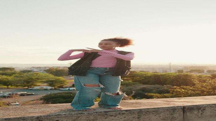 Young Woman Dances Barefoot on Rooftop at Sunset