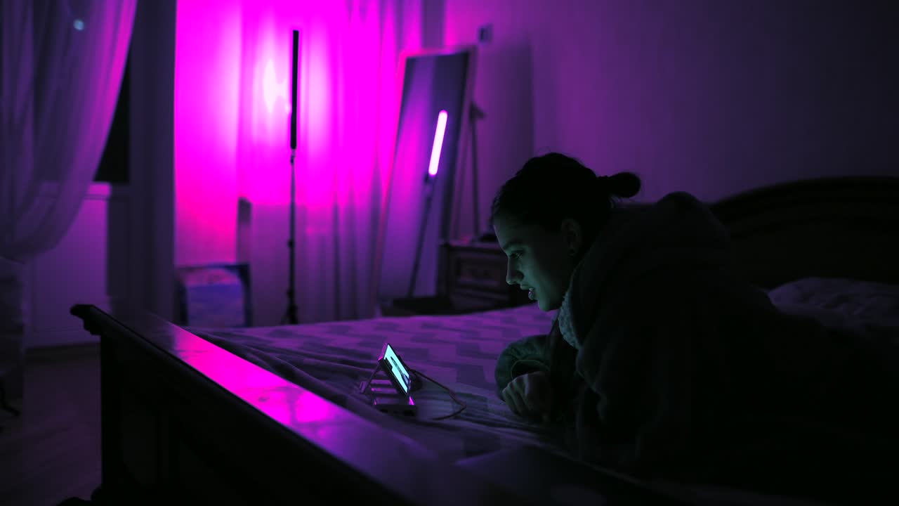 mujer acostada en la cama por la noche, mirando el teléfono