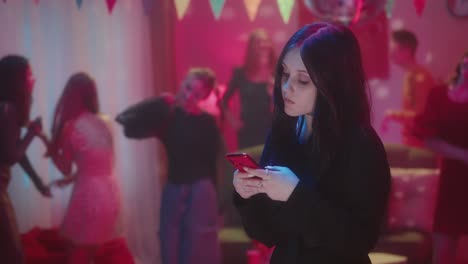 teenager at a party using her mobile phone