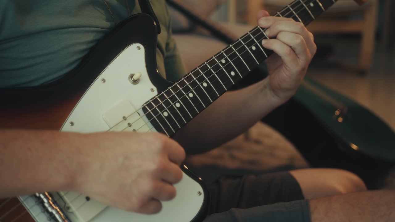Primo piano di mani che suonano la chitarra elettrica.