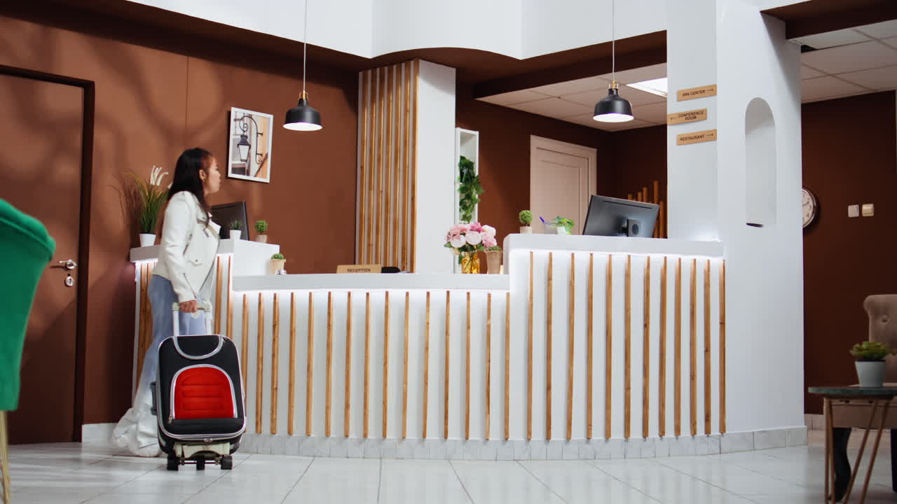 Asian tourists entering hotel lobby and using service bell