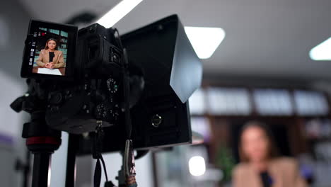 camera records a video with a beautiful female speaker in beige jacket. low angle view close up. blogging concept.