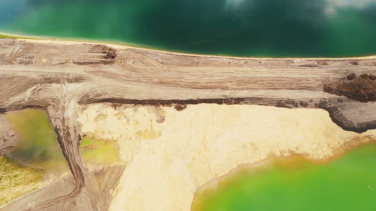 Top aerial view of sand works on the muddy Velenje Lake shore