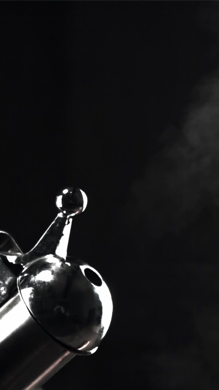 Polished Metal Object Emitting White Steam on Black Background