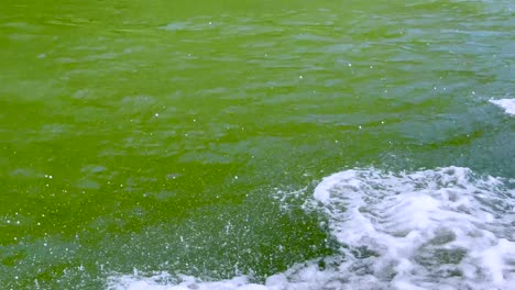 boat creates splashes and rainbow in canal