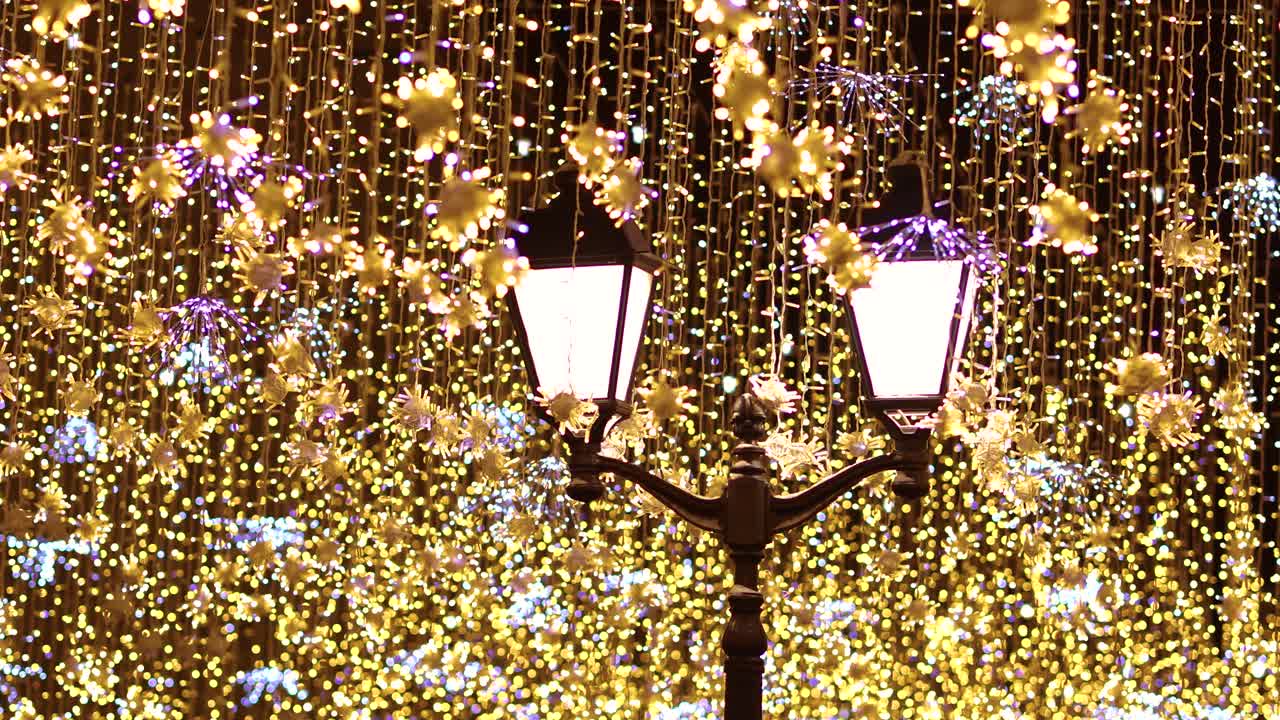 装飾的なクリスマスの花輪が付いている通りのランタン。新年とクリスマスのお祝い。
