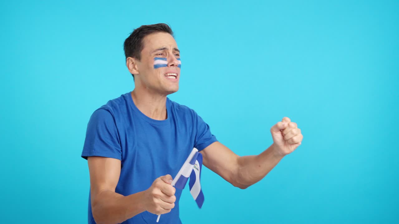 Nervous man cheering for El Salvador during a match looking away