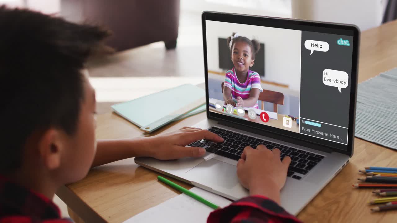 escolar que usa una computadora portátil para una lección en línea en casa, con una estudiante y un webchat en la pantalla