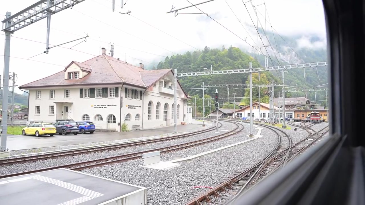Blick aus dem Zugwaggon bei der Einfahrt in den Bahnhof außerhalb von Interlaken, Schweiz.