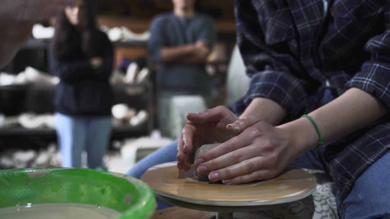 Woman making pottery on a pottery wheel