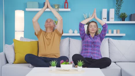 una pareja casada meditando en casa.