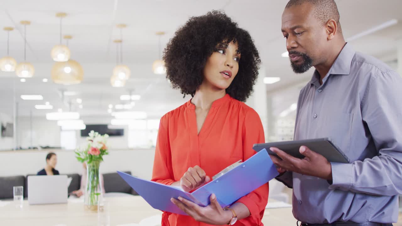 Group of diverse business people holding documents and talking in office, slow motion